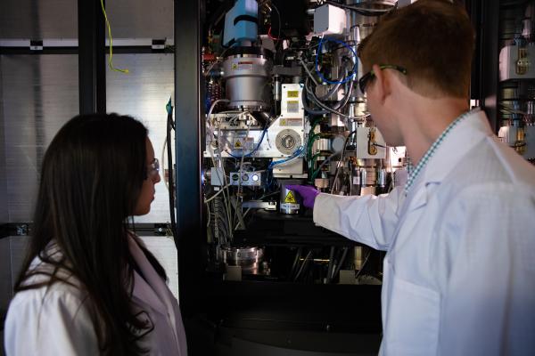 Image of research associate Megan Mayer and graduate student Patrick Mitchell loading a sample into one of SLAC's new cryogenic electron microscopes. 